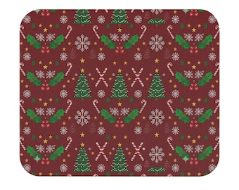 以下が含まれることがあります： クリスマスツリー、雪の結晶、キャンディケーン、ヒイラギ、星の繰り返し模様が特徴の、長方形のバーガンディ色のマウスパッド。お祝いのホリデーセーターを彷彿とさせるデザインです。