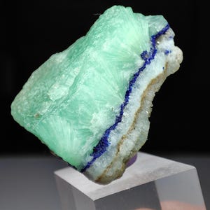 Puede incluir: Una taza de cerámica blanca con un asa negra y el texto "But First, Coffee" en negro y negrita. La taza está sobre una superficie de madera. La taza mide 10 cm de alto.