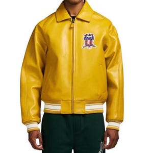 May include: A bright yellow leather jacket with a zip-up front, a collar, and a ribbed hem and cuffs with white stripes. The jacket features a patch on the chest with the word "AVIREX" and a patriotic design.