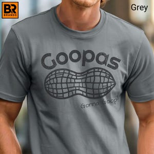 May include: Grey t-shirt with a graphic of a peanut and the word "Goopas" above it. The phrase "Gonna Goop!" is printed below the peanut graphic. The shirt has a crew neck and short sleeves.
