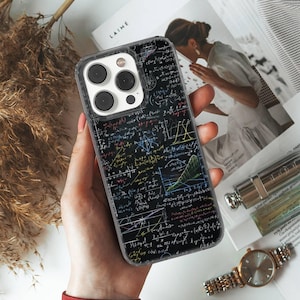 Op de afbeelding: Een doorzichtige telefoonhoes met een zwarte achtergrond bedekt met kleurrijke wiskundige vergelijkingen en diagrammen. De hoes wordt in een hand gehouden en de cameralenzen van de telefoon zijn zichtbaar. Het is een beschermend accessoire voor een smartphone.