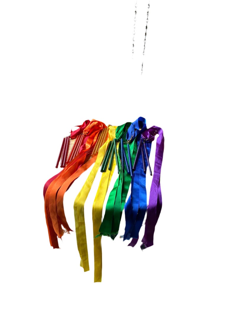 May include: A set of rainbow colored ribbons hanging from a ceiling. The ribbons are tied together at the top and are flowing down in a cascade.