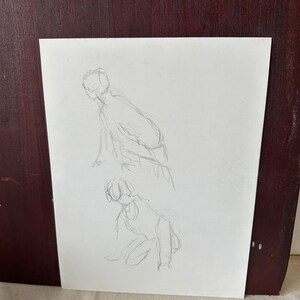 以下が含まれることがあります： 白い紙に2体の人物の鉛筆スケッチ。人物は緩やかなジェスチャーで描かれている。上のほうの人物はかがんでおり、下のほうの人物はひざまずいている。