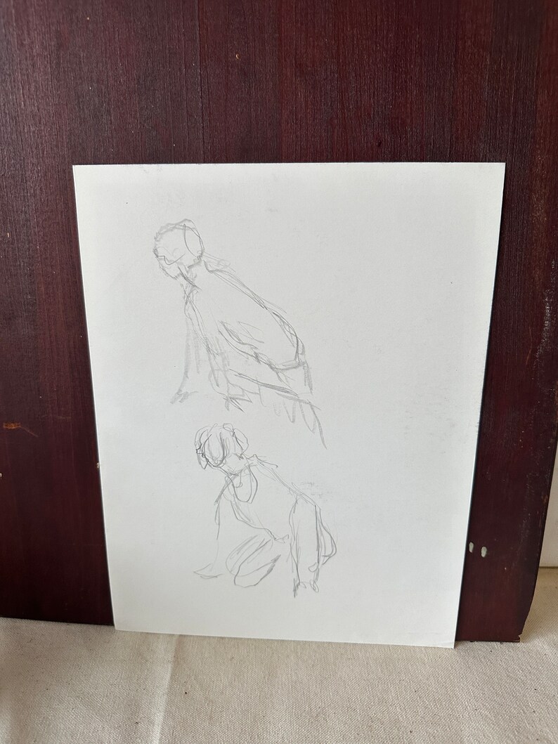 以下が含まれることがあります： 白い紙に2体の人物の鉛筆スケッチ。人物は緩やかなジェスチャーで描かれている。上のほうの人物はかがんでおり、下のほうの人物はひざまずいている。