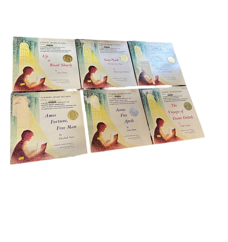 May include: A collection of six Newbery Award winning children's books. The books are all hardcover and feature illustrations on the covers. The titles of the books are "Up a Road Slowly", "Gay-Ned: The Story of a Pioneer", "Amos Fortune, Free Man", "Across Five Aprils", "The Voyages of Doctor Dolittle", and "The Story of a Pioneer".