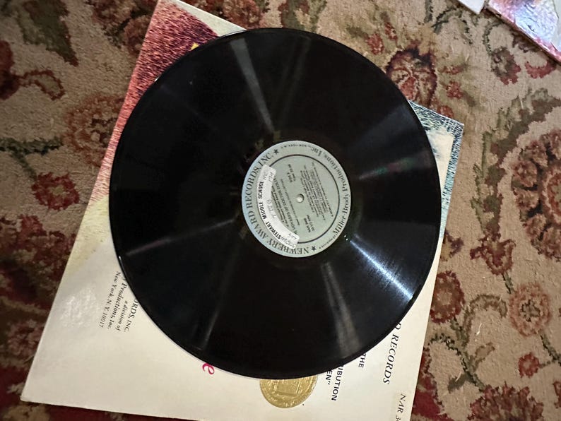 May include: A black vinyl record with a white label that reads "NEWSTREET" "SPECIAL RECORD" "MILLER" "HIGH SCHOOL" "RECORDING INC."