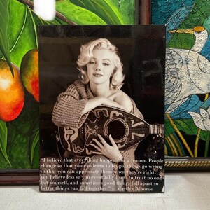 K&ouml;nnte beinhalten: Schwarz-Wei&szlig;-Druck mit Marilyn Monroe, die eine Mandoline h&auml;lt. Das Bild enth&auml;lt ein Zitat, das ihr zugeschrieben wird. Der Druck ist rechteckig und gerahmt, mit dunklem Hintergrund.