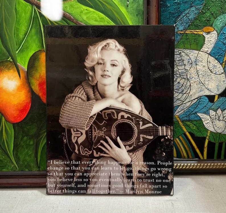 K&ouml;nnte beinhalten: Schwarz-Wei&szlig;-Druck mit Marilyn Monroe, die eine Mandoline h&auml;lt. Das Bild enth&auml;lt ein Zitat, das ihr zugeschrieben wird. Der Druck ist rechteckig und gerahmt, mit dunklem Hintergrund.