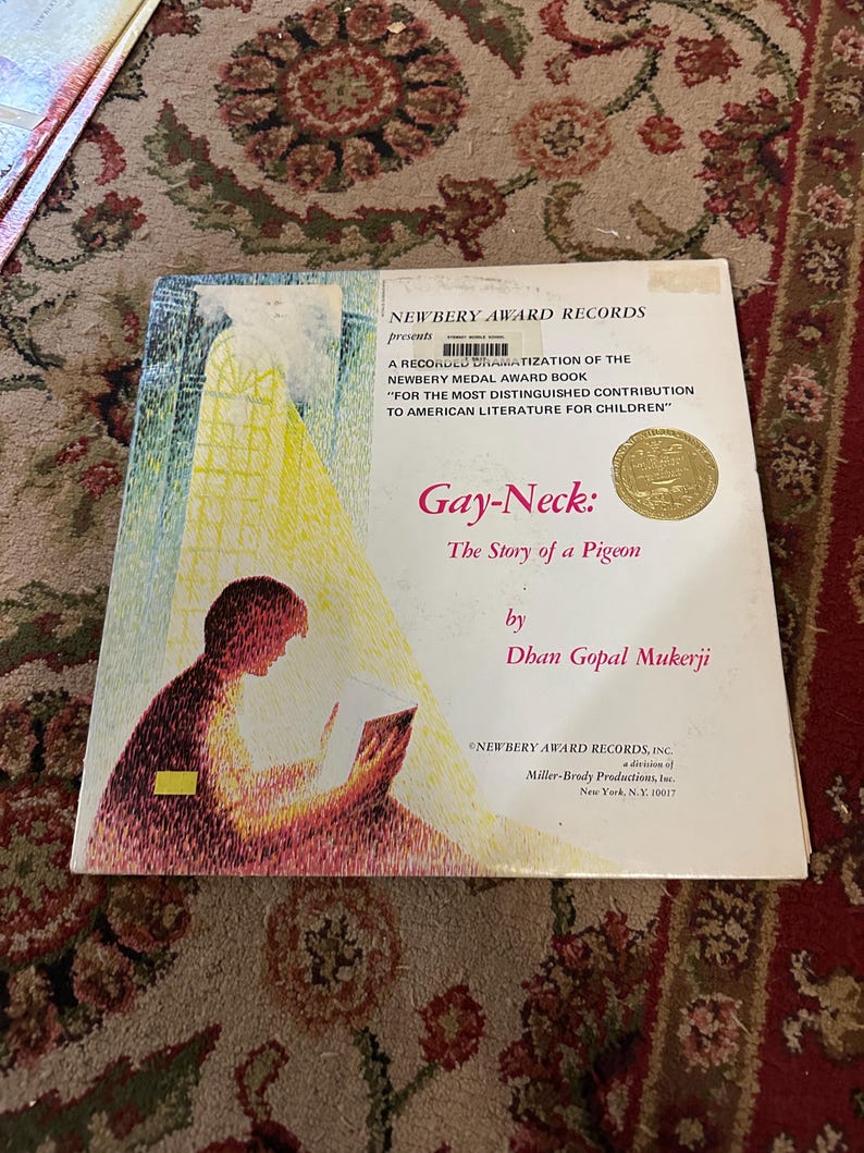 May include: A book cover with a yellow and red illustration of a person reading. The title is "Gay-Neck: The Story of a Pigeon" by Dhan Gopal Mukerji. The book is a recorded dramatization of the Newbery Medal Award book.