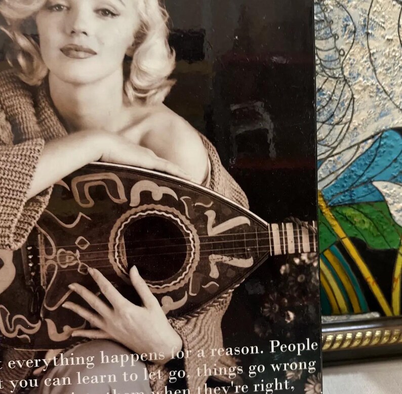 K&ouml;nnte beinhalten: Schwarz-Wei&szlig;-Fotografie einer Frau, die eine Mandoline h&auml;lt. Die Mandoline ist dunkel mit dekorativen Mustern. Die Frau tr&auml;gt einen Pullover. Der Text unten lautet: "Alles geschieht aus einem Grund. Menschen, man kann loslassen lernen, Dinge gehen schief, wenn sie richtig sind."