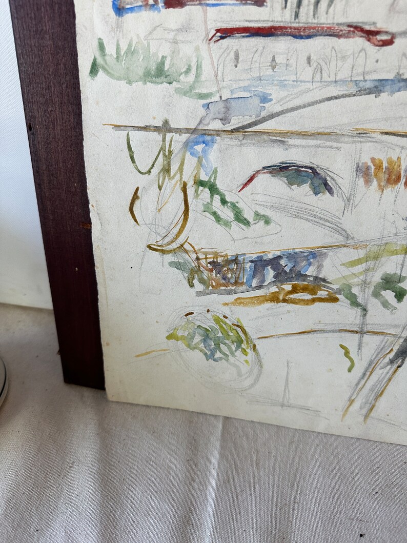 Puede incluir: Una pintura al agua enmarcada con formas y l&iacute;neas abstractas en tonos de verde, azul, marr&oacute;n y amarillo. La pintura est&aacute; sobre un fondo blanco y tiene un marco de madera marr&oacute;n.