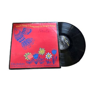 Puede incluir: Una portada de disco de vinilo rojo con una ilustración de pájaro colorido y el texto "You'll Sing a Song and I'll Sing a Song Newton Ella Jenkins with Members of the Urban Gateways Children's Chorus".