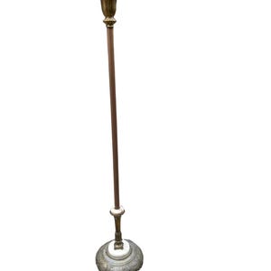 Puede incluir: Una l&aacute;mpara de pie antigua con una parte superior y una base de color bronce, un poste marr&oacute;n oscuro y un acento blanco. La l&aacute;mpara tiene un dise&ntilde;o ornamental y decorativo y probablemente est&aacute; hecha de metal. La l&aacute;mpara es alta y esbelta.