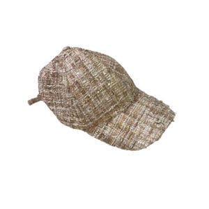 May include: A tweed baseball cap in shades of tan, brown, and gold. The cap features a curved brim and a classic six-panel design. The fabric has a textured appearance with subtle sequin accents, adding a touch of sparkle.