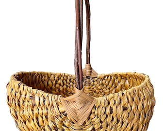Cesta de mimbre vintage tejida a mano con asa marrón.