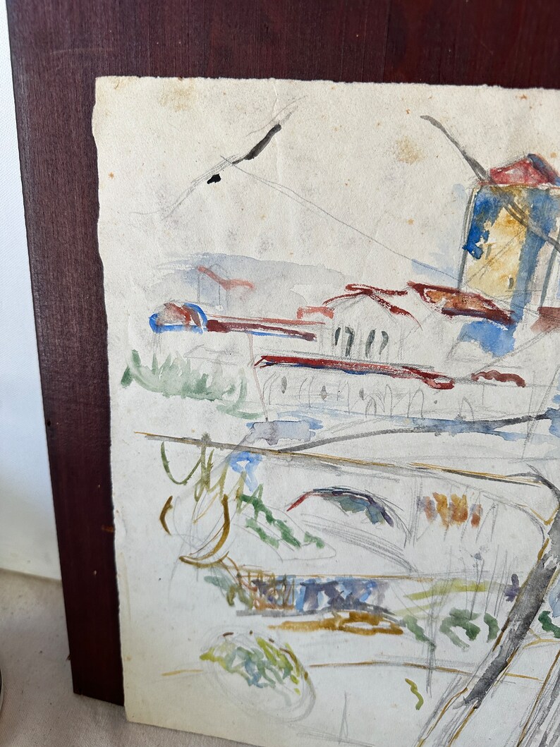 Puede incluir: Una pintura de acuarela de un paisaje con edificios, &aacute;rboles y un r&iacute;o. La pintura est&aacute; hecha en tonos de azul, verde, marr&oacute;n y rojo.