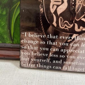 K&ouml;nnte beinhalten: Gerahmter Druck mit einem Zitat in wei&szlig;em Text auf sepiafarbenem Hintergrund. Das Zitat beginnt mit "Ich glaube, dass alles" und setzt sich &uuml;ber mehrere Zeilen fort. Der Rahmen ist dunkelbraun.