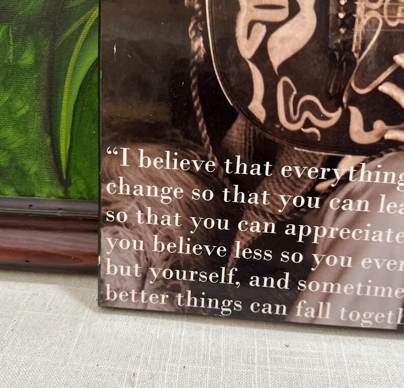 K&ouml;nnte beinhalten: Gerahmter Druck mit einem Zitat in wei&szlig;em Text auf sepiafarbenem Hintergrund. Das Zitat beginnt mit "Ich glaube, dass alles" und setzt sich &uuml;ber mehrere Zeilen fort. Der Rahmen ist dunkelbraun.