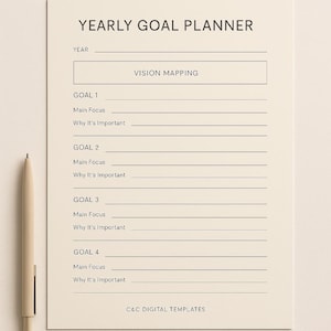 Puede incluir: Un planificador de objetivos anuales de color crema con el texto "YEARLY GOAL PLANNER" en la parte superior. El planificador incluye secciones para la planificación de la visión, objetivos, enfoque principal y por qué es importante. Un bolígrafo descansa en el lado izquierdo.