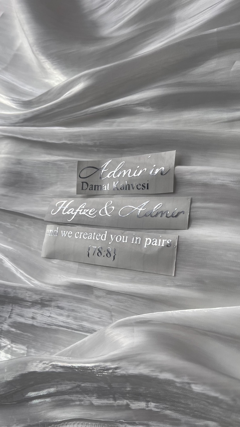May include: Three rectangular labels with silver text on a grey background. The top label reads "Admir in Damat Kahvesi." The middle label says "Hafize & Admir." The bottom label reads "and we created you in pairs {78:8}."