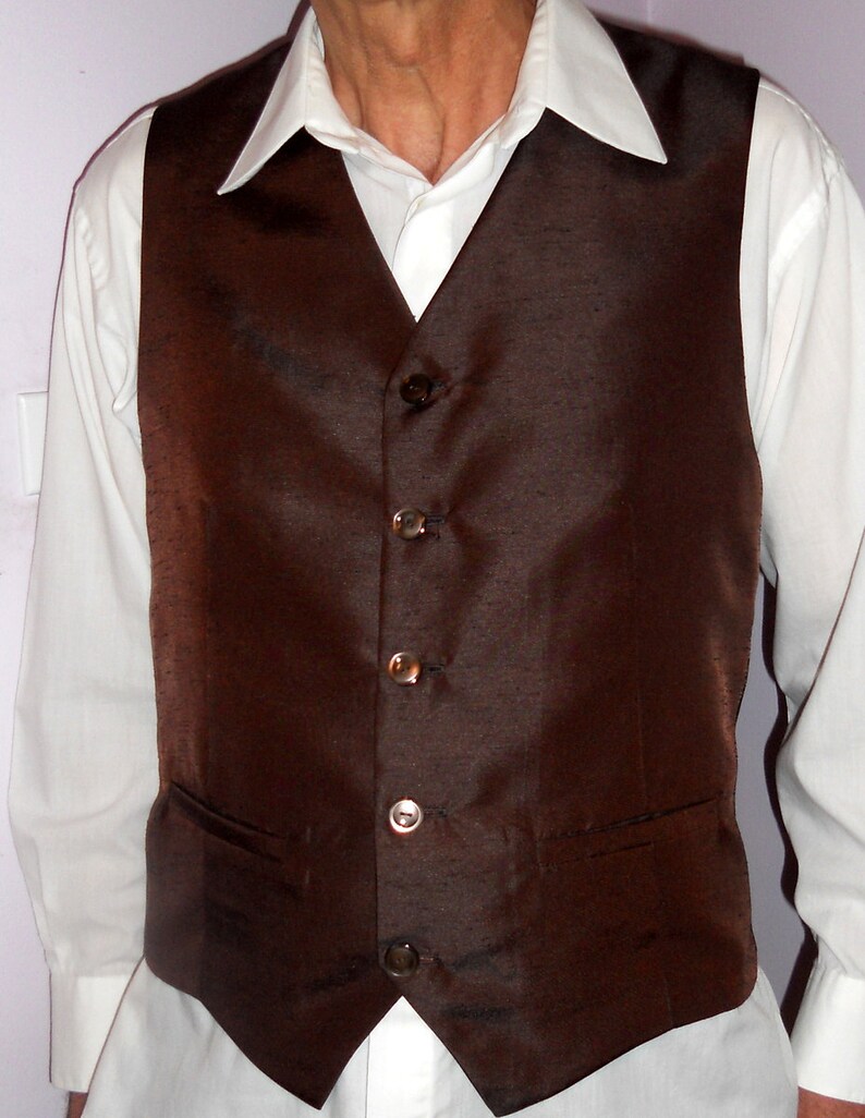 May include: A brown satin vest with five silver buttons. The vest has a pocket on the left side.