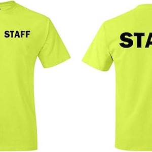 May include: A neon yellow t-shirt with the word "STAFF" printed in black on the front and back. The shirt has short sleeves and a crew neck. The text is centered on both sides of the shirt.