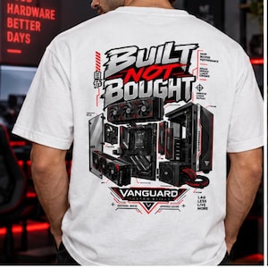 May include: A white t-shirt featuring a large graphic on the back. The design includes the text "BUILT NOT BOUGHT" and "VANGUARD" in black and red, alongside an exploded view illustration of a computer tower, motherboard, and graphics card.