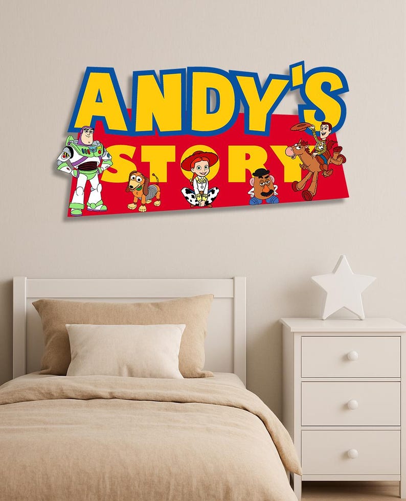 K&ouml;nnte beinhalten: Eine farbenfrohe Wanddekoration mit dem Text "ANDY'S STORY" in Gelb und Blau, mit Zeichentrickfiguren aus dem Film Toy Story. Zu den Figuren geh&ouml;ren Buzz Lightyear, Woody, Jessie und andere. Die Dekoration ist &uuml;ber einem Bett angebracht.
