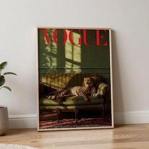 Puede incluir: Impresión enmarcada con la palabra "VOGUE" en rojo. La imagen muestra un guepardo descansando en un sofá verde. El fondo es una pared verde con sombras. La impresión está en un marco de madera.
