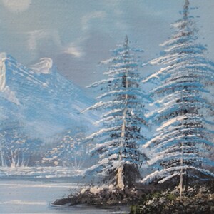 Puede incluir: Una pintura de paisaje de invierno nevado con dos altos pinos cubiertos de nieve en primer plano. Los &aacute;rboles est&aacute;n frente a un lago y monta&ntilde;as en el fondo. El cielo es de un azul claro con una luna blanca.