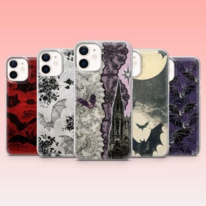 May include: A collection of five phone cases with various gothic and Halloween-themed designs. The cases feature bats, lace, a full moon, and a church. Colors include red, black, white, purple, and gray. The cases are displayed against a pink background.