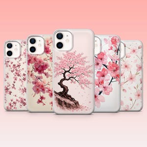 Peut inclure: Une collection de cinq coques de téléphone avec des motifs floraux. Les coques présentent diverses illustrations de fleurs de cerisier roses sur un fond blanc ou rose clair. Les motifs incluent des arbres entiers, des branches et des pétales épars.