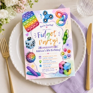 May include: A rectangular birthday invitation card featuring watercolor illustrations of various fidget toys including a rainbow pop-it, blue spinner, and green pea popper. The text reads: You're Invited! Fidget Party! to celebrate Addison's 8th Birthday!