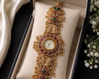 Kaschmirische goldfarbene Armbanduhr, ethnischer Armreif im Kundan-Stil, rote und grüne Steine