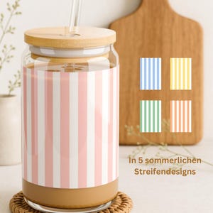 May include: A clear glass tumbler with a bamboo lid and a glass straw, featuring a pink and white vertical striped pattern. To the right, four small squares display additional blue, yellow, green, and orange striped color options.