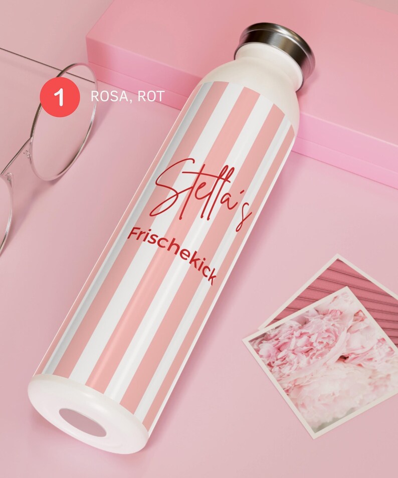 May include: A white water bottle with vertical light pink stripes, a silver-toned cap, and red text that reads "Stella's Frischekick". The bottle also features a small red circle with the number 1 and the text "ROSA, ROT" printed near the top.