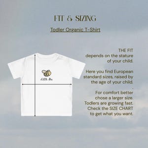 May include: White toddler organic t-shirt with a small bee graphic. The image includes text about sizing, stating the fit depends on the child's stature and offers European standard sizes. The text also advises choosing a larger size for comfort.