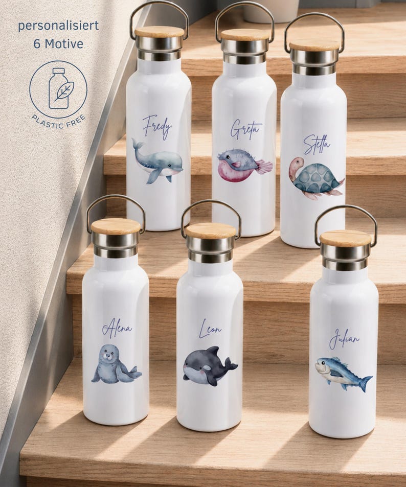 May include: Six white metal water bottles with bamboo lids and metal handles. Each bottle features a unique watercolor sea creature illustration and a personalized name in cursive script. Text on the image reads: personalisiert 6 Motive PLASTIC FREE.
