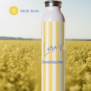 May include: A white water bottle with vertical yellow stripes. The text "Lara's Durstl&ouml;scher" is printed in blue on the front. The bottle has a metallic silver cap. A yellow circle with the number 3 and the text "GELB, BLAU" is visible.