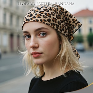 Può includere: Una bandana con motivo leopardato è indossata sulla testa. La bandana è beige con macchie marroni. Il testo "LEOPARD PATTERN BANDANA" è nella parte superiore dell'immagine. La persona nell'immagine indossa una maglietta nera.