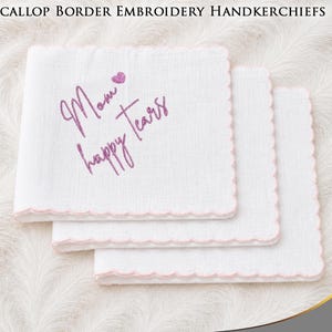 Peut inclure: Trois mouchoirs carrés blancs avec des bords festonnés soulignés par un fil rose clair. Le mouchoir du dessus présente une broderie rose avec le texte Mom happy tears et une petite icône de cœur rose placée au-dessus du mot Mom.