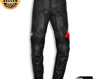 May include: Black leather motorcycle pants with a red and white logo on the side. The pants have reinforced panels at the knees and a button and zipper closure. The pants are designed for motorcycle riding.
