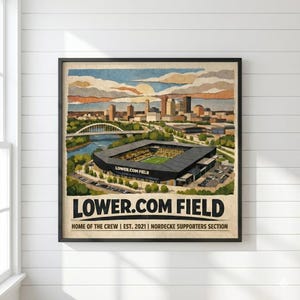 May include: Framed art print featuring a watercolor illustration of Lower.com Field, a stadium with a green field and seating. The artwork includes a cityscape, a river, and the text "LOWER.COM FIELD". The print also includes the text "HOME OF THE CREW | EST. 2021 | NORDECKE SUPPORTERS SECTION."