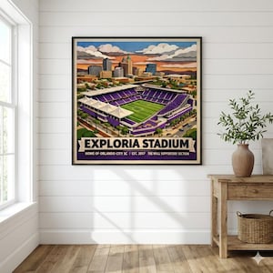 Puede incluir: Una impresión artística enmarcada del estadio Exploria, sede del Orlando City SC. El estadio está representado en morado y blanco, con un campo verde, sobre un paisaje urbano y un cielo al atardecer. La impresión incluye el texto "Exploria Stadium".