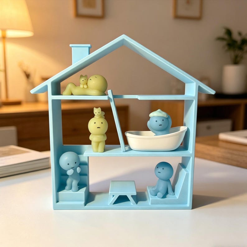 May include: A light blue miniature house-shaped shelf unit with several small, whimsical figurines. The figurines are in various poses, including reclining, standing, and seated. The shelf has a chimney and a ladder. The figurines are in shades of yellow and blue.