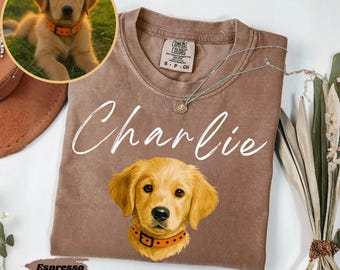 Może przedstawiać: Koszulka w kolorze espresso z grafiką szczeniaka golden retrievera i napisem "Charlie" w białym skrypcie. Koszulka zawiera mały okrągły obrazek szczeniaka i metkę Comfort Colors.