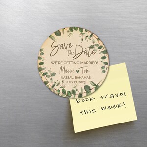 May include: A round save the date magnet with a floral design. The text reads "Save the Date" with a heart and the names "Maeve" and "Tom". The location is Nassau, Bahamas and the date is 27 July 2023.