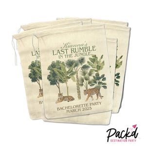 May include: Set of six beige fabric bags with a jungle theme. The bags feature a green and brown illustration of palm trees, leaves, and tigers. The text on the bags reads "Kianna's Last Rumble in the Jungle" and "Bachelorette Party March 2025".