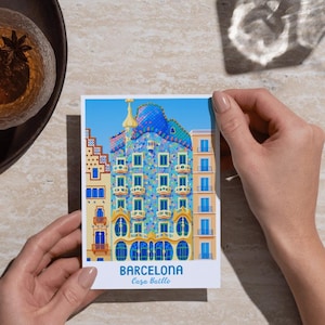 May include: A postcard featuring a colorful illustration of Casa Batll&oacute; in Barcelona. The building has a blue, mosaic-tiled roof and ornate facade with arched windows. The text "BARCELONA Casa Batll&oacute;" is printed at the bottom against a blue sky background.