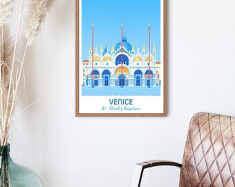 May include: A framed art print featuring a stylized illustration of St. Mark's Basilica in Venice, Italy, under a bright blue sky. The print includes the text "VENICE" and "St. Mark's Basilica" in a white font. The frame is a light brown color.